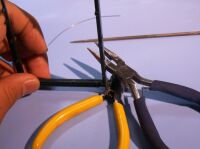 カッターを下敷きにして、プライヤで打ち込む